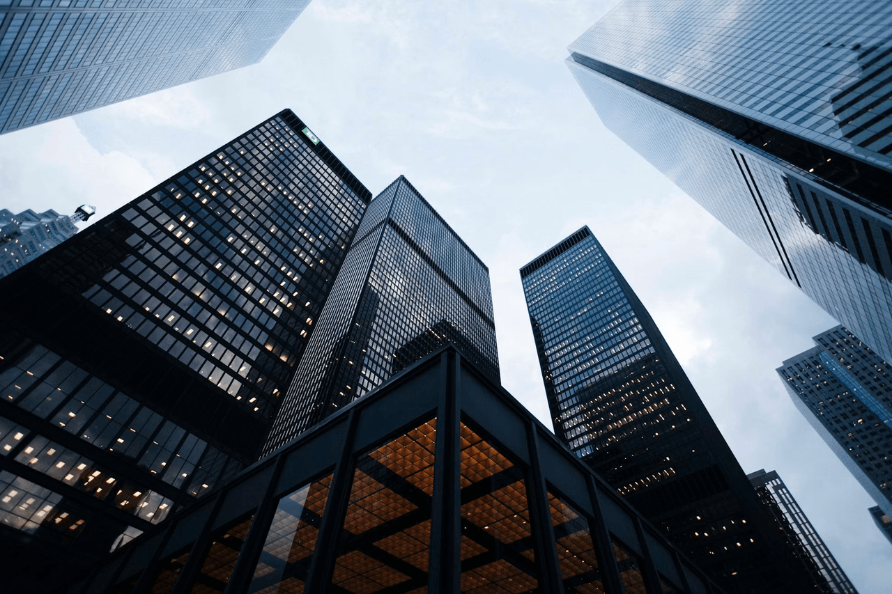 Low-angle view of glass office skyscrapers against the sky